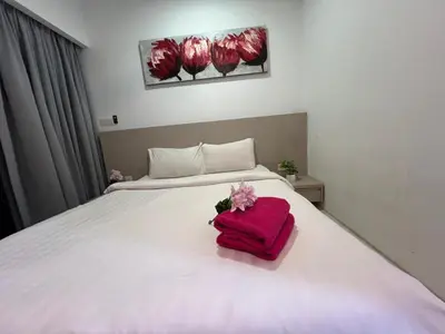 a white bed with a pink towel on it at Elegant Home at Mercu Summer Suites By KLCC in Kuala Lumpur