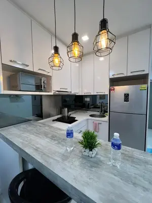 a kitchen with a counter with two water bottles on it at Elegant Home at Mercu Summer Suites By KLCC in Kuala Lumpur