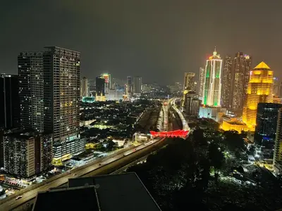a city lit up at night with cars on a freeway at Elegant Home at Mercu Summer Suites By KLCC in Kuala Lumpur