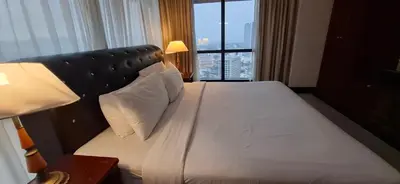 a bed in a hotel room with a large window at Kuala Lumpur Service suite times square s in Kuala Lumpur