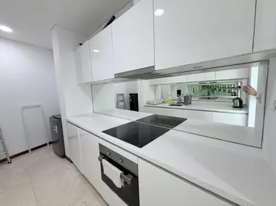 a white kitchen with white cabinets and a sink at Vortex Klcc By welcomes in Kuala Lumpur