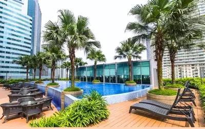 a resort with a swimming pool and palm trees at Vortex Klcc By welcomes in Kuala Lumpur