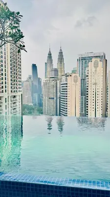 a swimming pool in front of a city skyline at Majestic Suites KLCC by Aman Tokyo in Kuala Lumpur