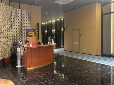 a lobby with people sitting at a counter in a building at Majestic Suites KLCC by Aman Tokyo in Kuala Lumpur