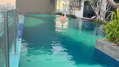 a boy in the swimming pool of a hotel at Majestic Suites KLCC by Aman Tokyo in Kuala Lumpur