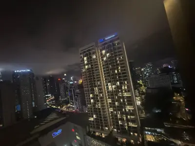a tall building with lights on top of it at night at Quill Residence King House in Kuala Lumpur