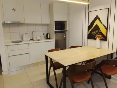 a kitchen with a wooden table and chairs at Mix Home At Chamber Residence in Kuala Lumpur