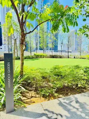 a sign in a park with a tree and buildings at Agile Residence By Infinity Pool in Kuala Lumpur