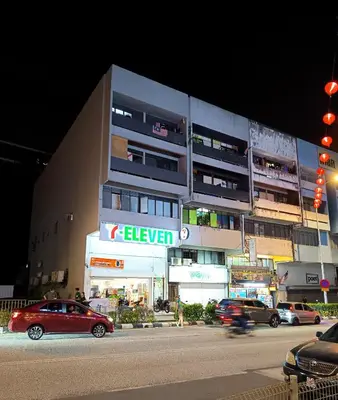 a red car driving down a street in front of a building at Chambers Residence Specious Suites KlCC in Kuala Lumpur