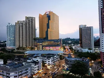 a city with tall buildings and traffic in a city at Chambers Residence Specious Suites KlCC in Kuala Lumpur