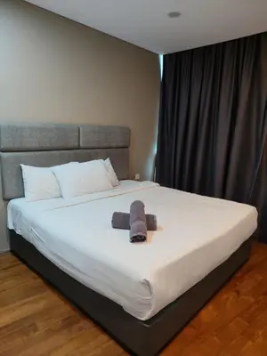 a bed with a stuffed animal sitting on it at Vortex Suite Klcc By Sky Moon in Kuala Lumpur