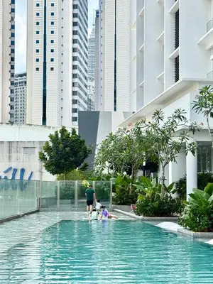 a family playing in a swimming pool in a city at Kuala Lumpur Quill Residences By AR Stay in Kuala Lumpur