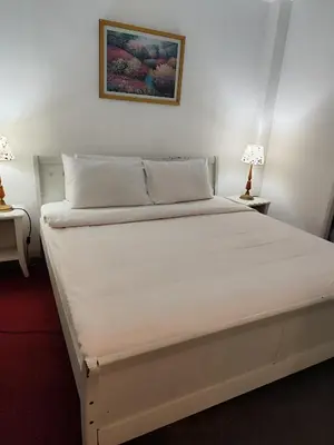 a white bed in a room with two lamps at Moonlight Apartment service at Times Square kl in Kuala Lumpur
