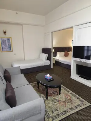 a hotel room with two beds and a couch and a tv at Moonlight Apartment service at Times Square kl in Kuala Lumpur