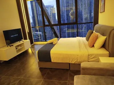 a bedroom with a bed and a tv and large windows at Scarletz suites Klcc by Sunlight in Kuala Lumpur