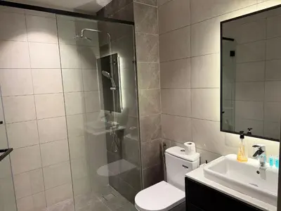 a bathroom with a shower and a toilet and a sink at Infinity pool luxury Apartment Axon in Kuala Lumpur