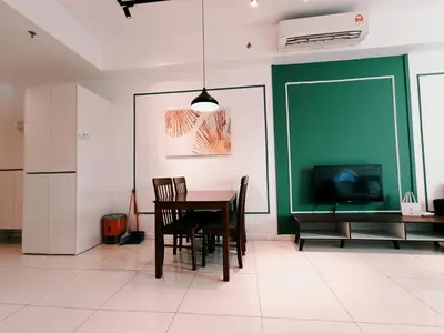a dining room with a table and a green wall at Chamber Residence KlCC by Royal Empire in Kuala Lumpur