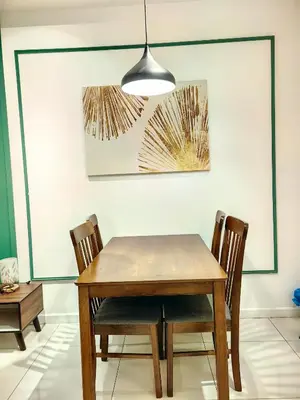 a dining room table with two chairs and a light fixture at Chamber Residence KlCC by Royal Empire in Kuala Lumpur