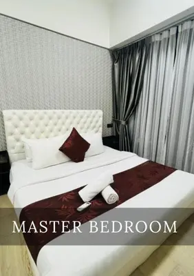 a bedroom with a white bed with a stuffed animal on it at Metro Star KLCC Living in Kuala Lumpur