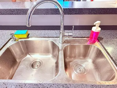 a kitchen sink with a faucet and a pink soap bottle at Relax and cozy, entire unit in Kuala Lumpur