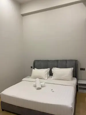a bedroom with a large bed with white sheets and pillows at Urban Star Residence KLCC in Kuala Lumpur