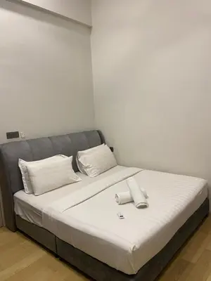 a bed with white sheets and pillows in a room at Urban Star Residence KLCC in Kuala Lumpur