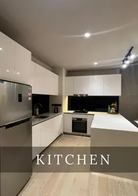 a kitchen with white cabinets and a silver refrigerator at Urban Star Residence KLCC in Kuala Lumpur