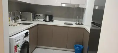 a kitchen with a sink and a washing machine at Elite Suites at Agile Bukit Bintang Kuala Lumpur in Kuala Lumpur