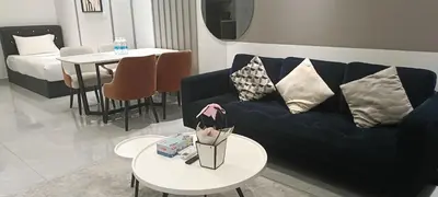 a living room with a blue couch and a table at Elite Suites at Agile Bukit Bintang Kuala Lumpur in Kuala Lumpur