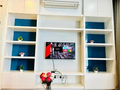 a living room with white shelves and a tv at The Grand klcc at platinum face in Kuala Lumpur