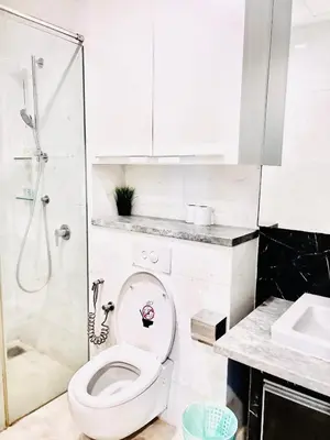 a white bathroom with a toilet and a shower at The Grand klcc at platinum face in Kuala Lumpur
