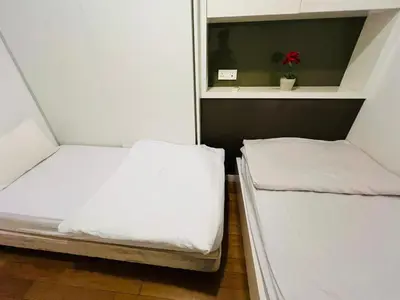 two beds in a small room with white sheets at The Grand klcc at platinum face in Kuala Lumpur