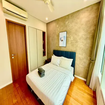 a bedroom with a bed with a green bag on it at Sky klcc by DMK luxury suites Apartment in Kuala Lumpur