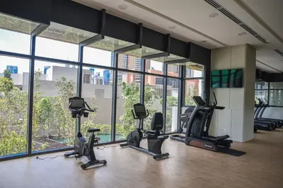a gym with treadmills and ellipticals in a building with windows at Glowing Star Home Infinity Swimming Pool By Lalaport in Kuala Lumpur