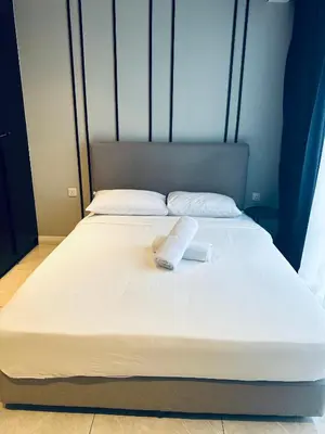 a large white bed with a towel on it at Luxury Residence At Axon in Kuala Lumpur