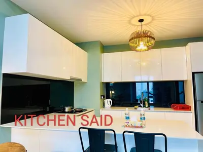 a kitchen with white cabinets and a chandelier at Star Residences Suites Home in Kuala Lumpur