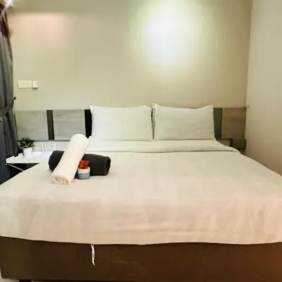 a bed with two pillows and a towel on it at LuxeHive Stay in Kuala Lumpur