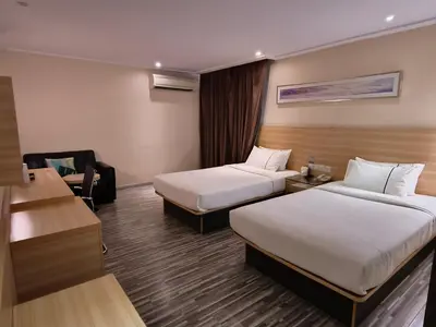 a hotel room with two beds and a desk at City Comfort Hotel Kuala Lumpur City Center (Bukit Bintang) in Kuala Lumpur