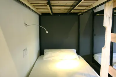 a bed in a small room with a lamp on it at Revopackers Beds and Bunks in Kuala Lumpur