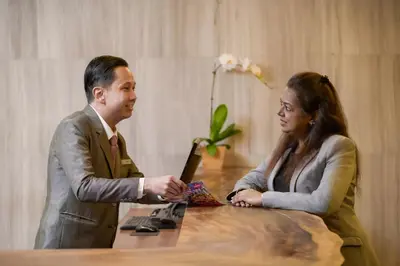 a man and a woman sitting at a table talking at Oasia Suites Kuala Lumpur by Far East Hospitality in Kuala Lumpur