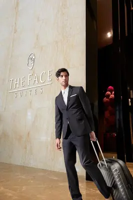 a man in a suit walking with a suitcase at THE FACE Suites Hotel in Kuala Lumpur