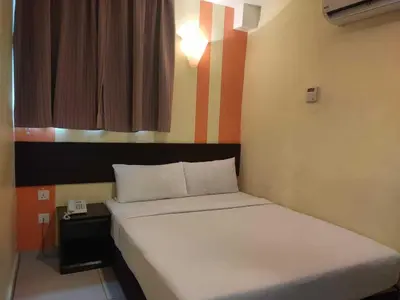 a bedroom with a bed and a phone in it at Sun Inns Hotel Sentral, Brickfields in Kuala Lumpur