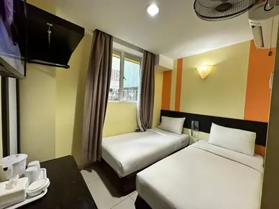 a hotel room with two beds and a table at Sun Inns Hotel Sentral, Brickfields in Kuala Lumpur