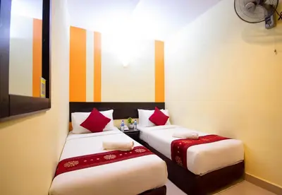 two beds in a small room with red pillows at Sun Inns Hotel Sentral, Brickfields in Kuala Lumpur