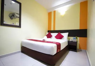 a hotel room with a large bed with red pillows at Sun Inns Hotel Sentral, Brickfields in Kuala Lumpur
