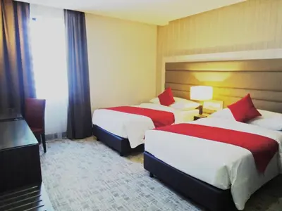 a hotel room with two beds and a television at Verdant Hill Hotel Kuala Lumpur in Kuala Lumpur