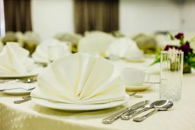 a table with white plates and silverware on it at Verdant Hill Hotel Kuala Lumpur in Kuala Lumpur