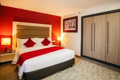 a bedroom with a large bed with red walls at Verdant Hill Hotel Kuala Lumpur in Kuala Lumpur