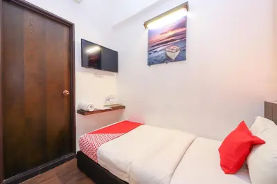 a small bedroom with a bed and a wooden door at Hotel O Madras in Kuala Lumpur