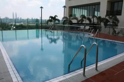 a large swimming pool with blue water in a building at Richone Maluri Private Hotel in Kuala Lumpur